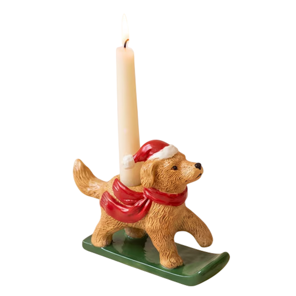 Ceramic golden retriever taper candleholder wearing a Santa hat and red scarf on a green sled.