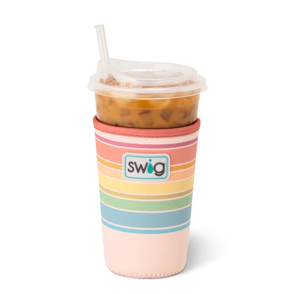An iced coffee cup in a Swig insulated sleeve with pastel rainbow stripes and a clear lid and straw.