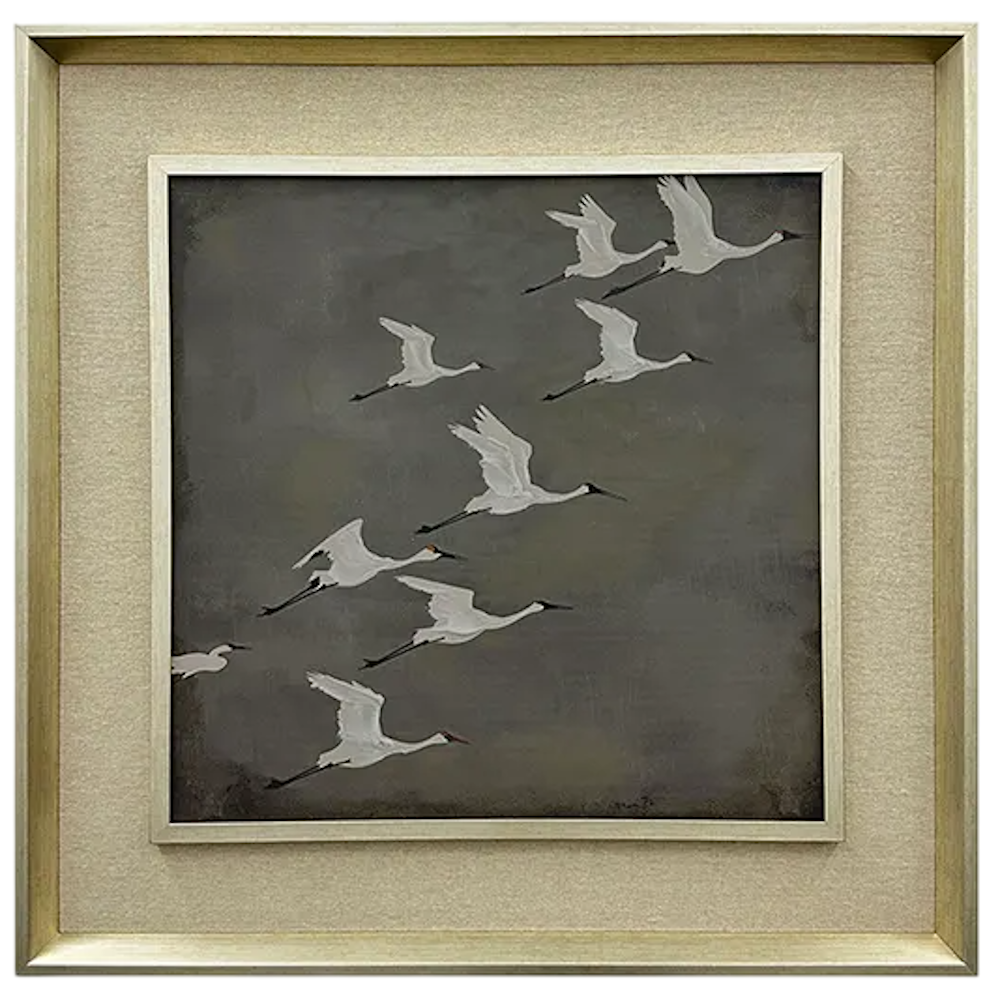 Framed artwork of white cranes flying against a gray background with a metallic gold frame.
