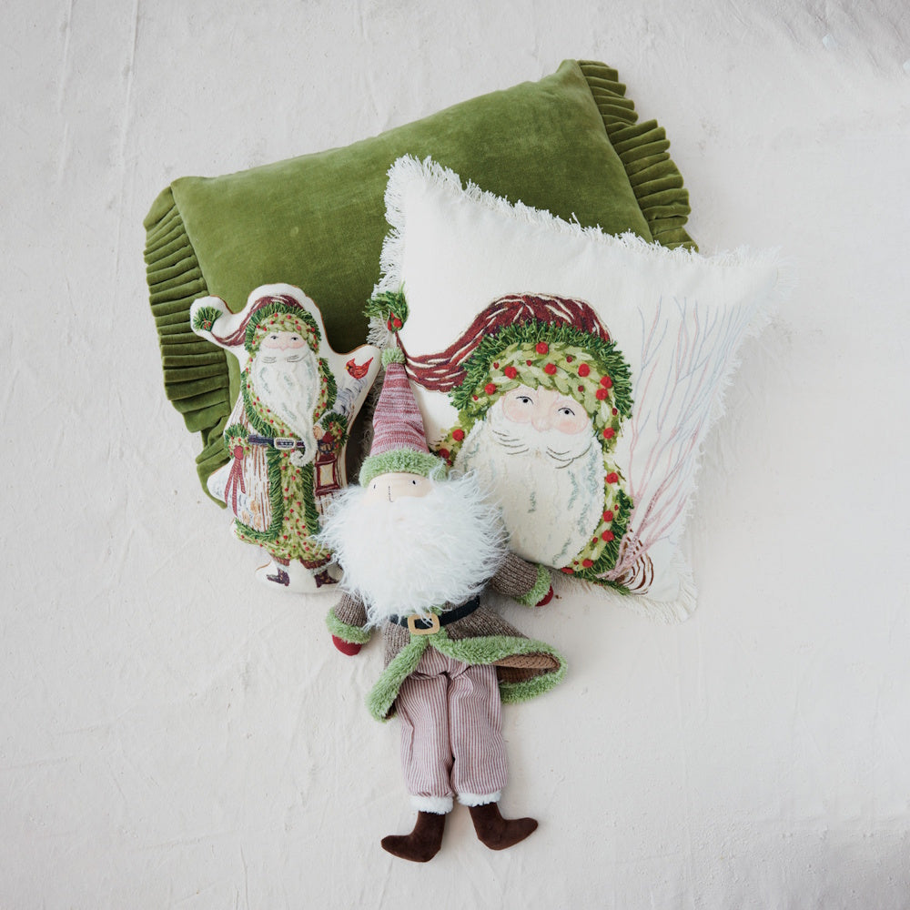 Green velvet ruffled pillow paired with Santa Claus themed decorative pillows and a plush gnome toy.