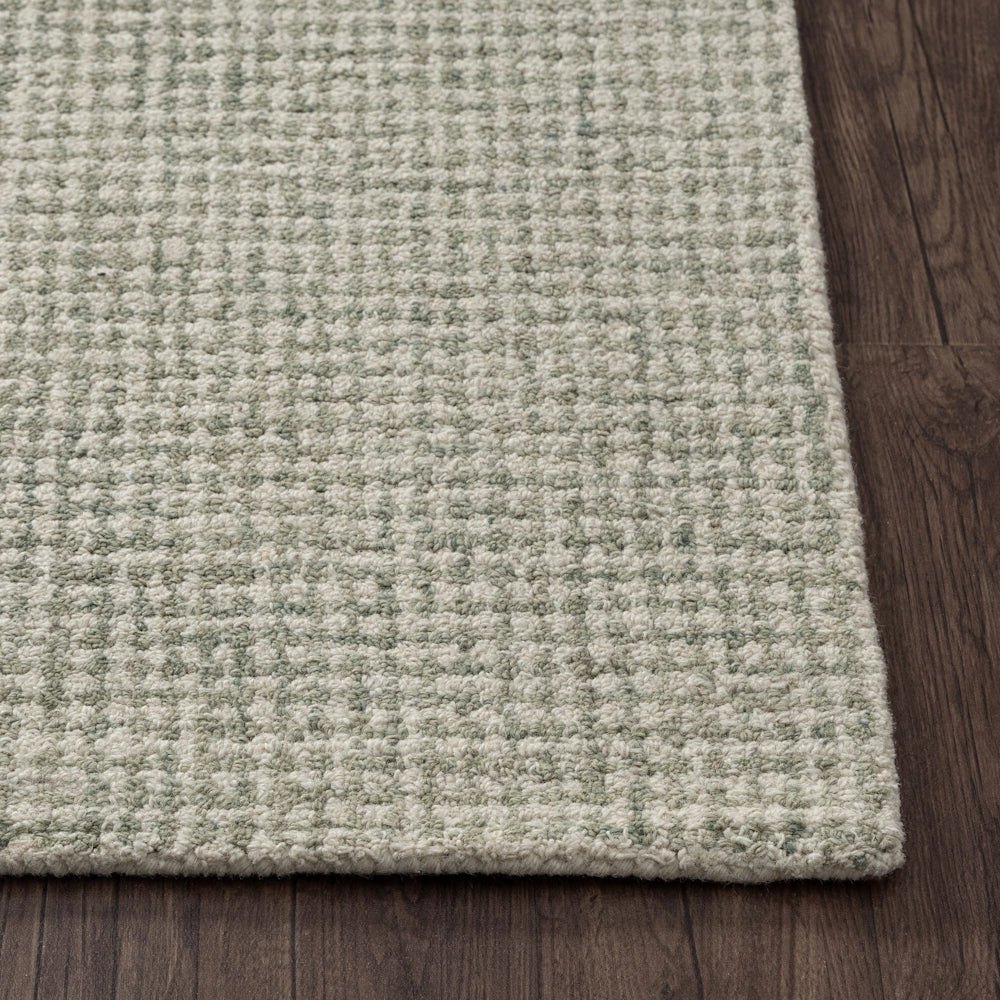 Textured light green and cream grid pattern wool area rug on dark wood floor.