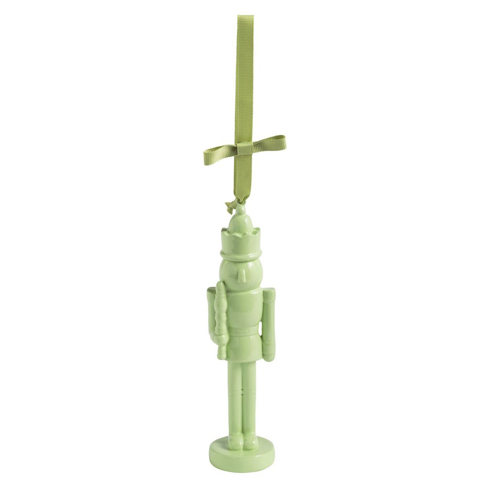 Glossy light green nutcracker Christmas ornament hanging from a matching ribbon bow.
