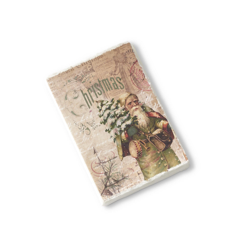 A soft-cover Christmas journal featuring a vintage illustration of Santa in a green coat holding a tree and a deckle edge.