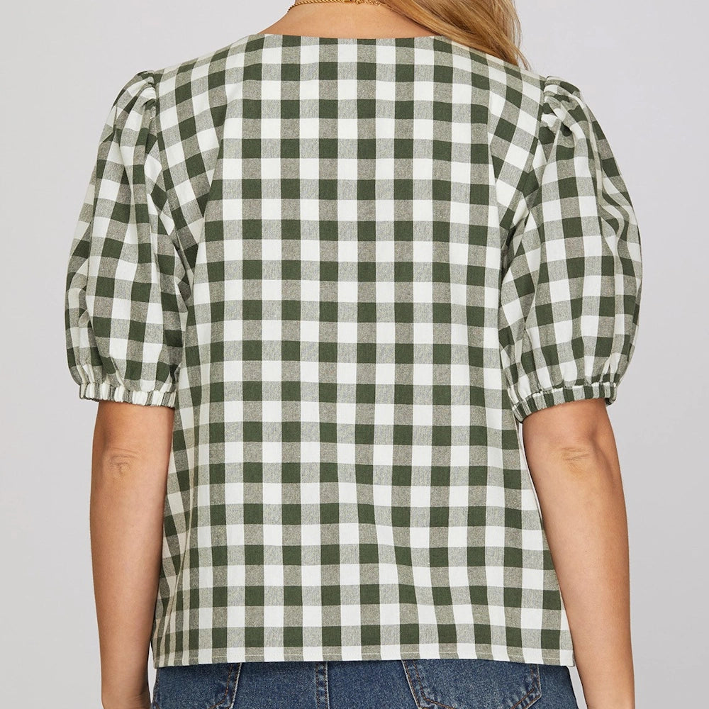 Back view of a green and white gingham checked top with short puff sleeves, paired with jeans.