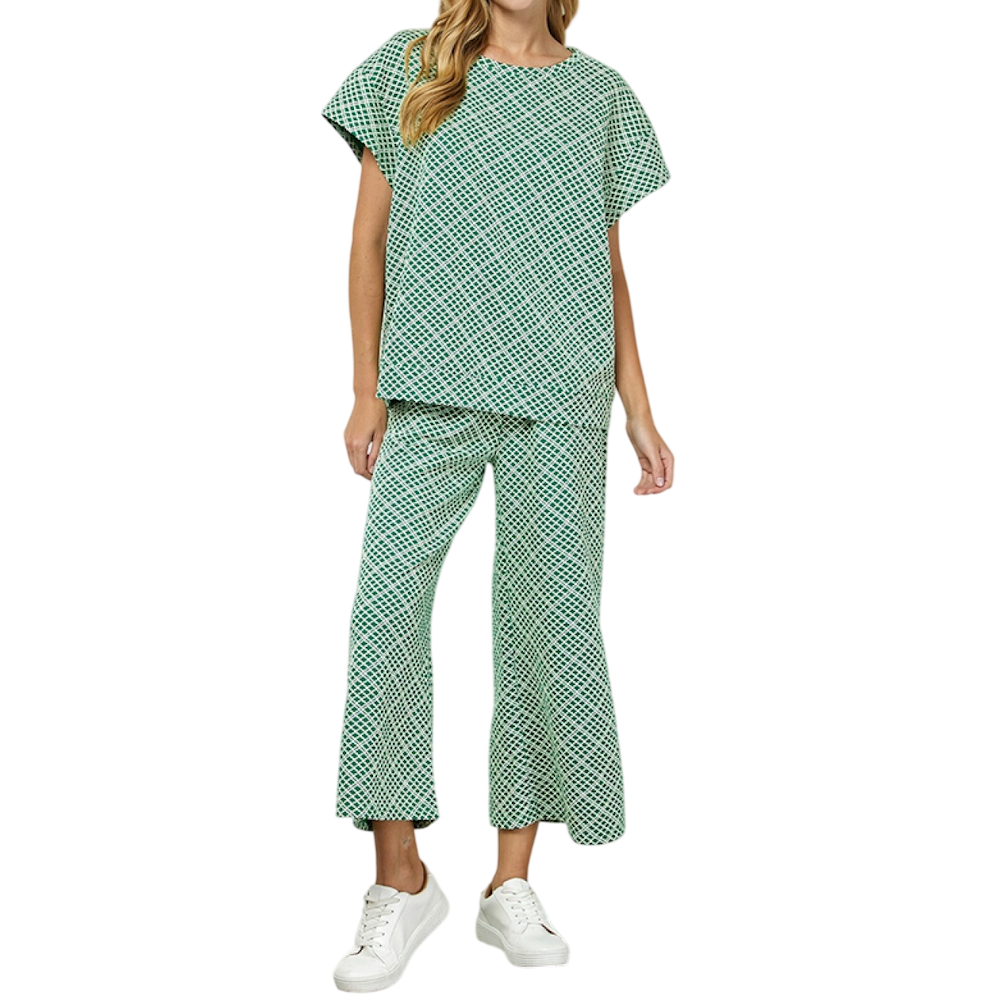 Woman in a green and white textured co-ord set with a short-sleeve top, cropped pants, and white sneakers.