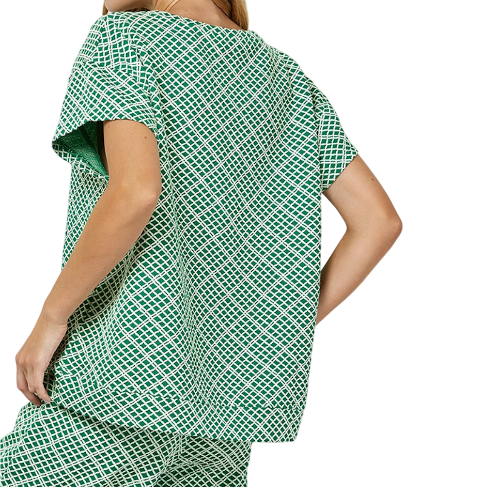 Woman from behind wearing a green and white geometric textured short-sleeve top and matching pants.