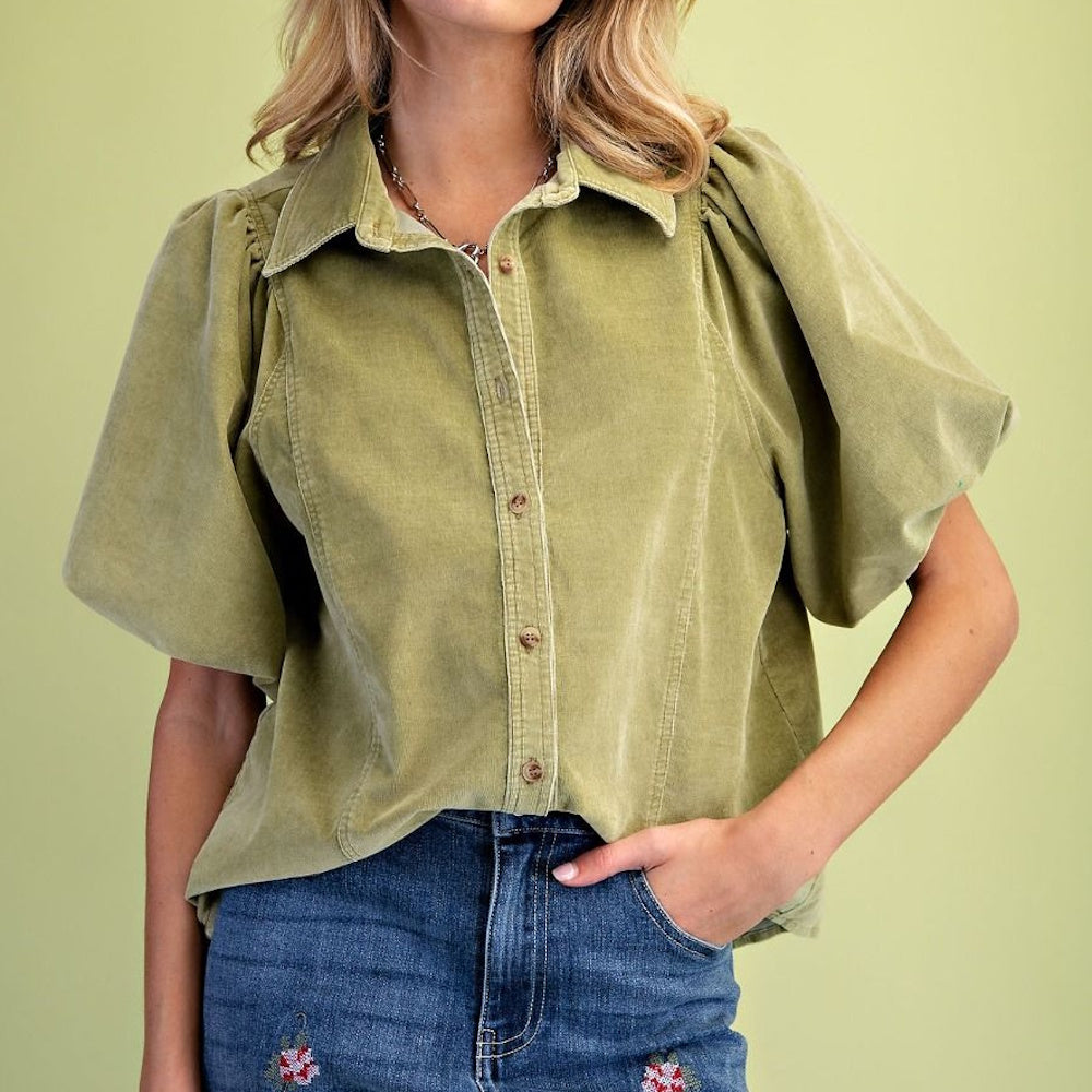 Front view of green-tea washed baby corduroy blouse French-tucked into denim jeans.
