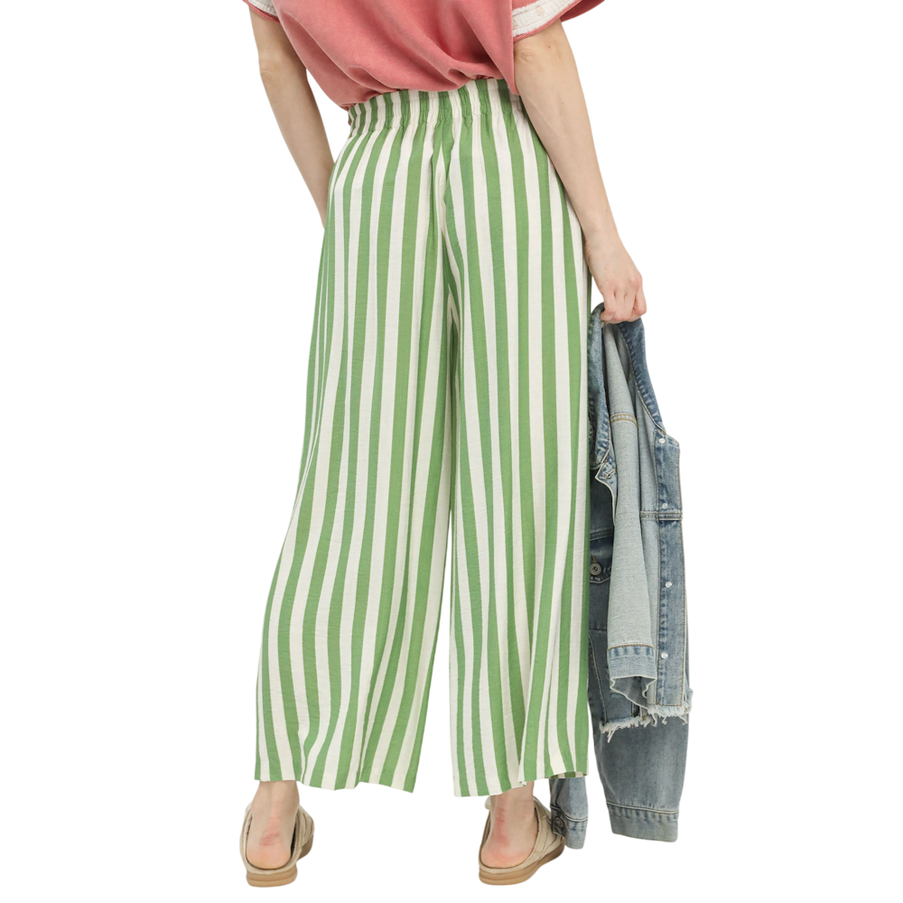 Rear view of wide-leg pants with green and white vertical stripes, paired with a red top and denim jacket.