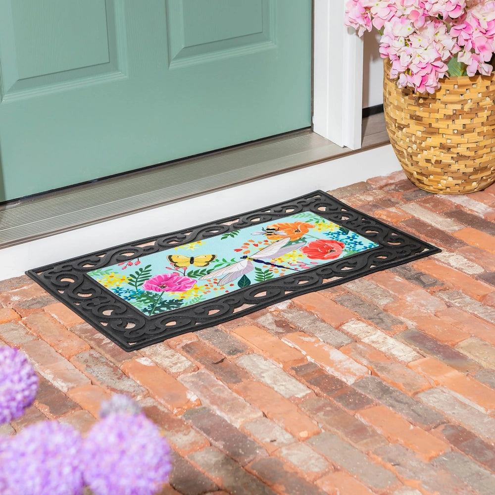 Greenhouse garden welcome mat with flowers, butterflies, and dragonflies on a brick porch by a teal door.