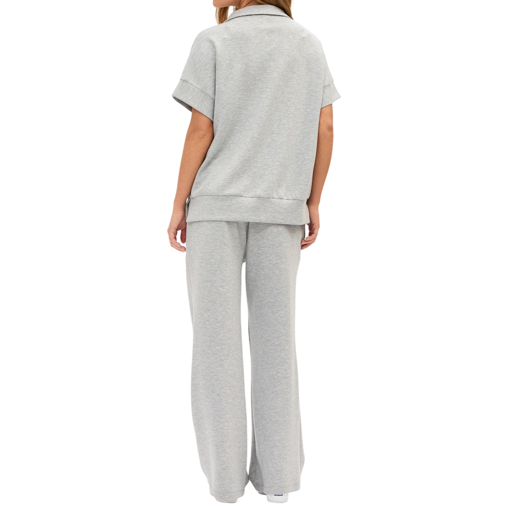 Rear view of a person wearing a grey short-sleeve shirt and matching wide-leg lounge pants set.