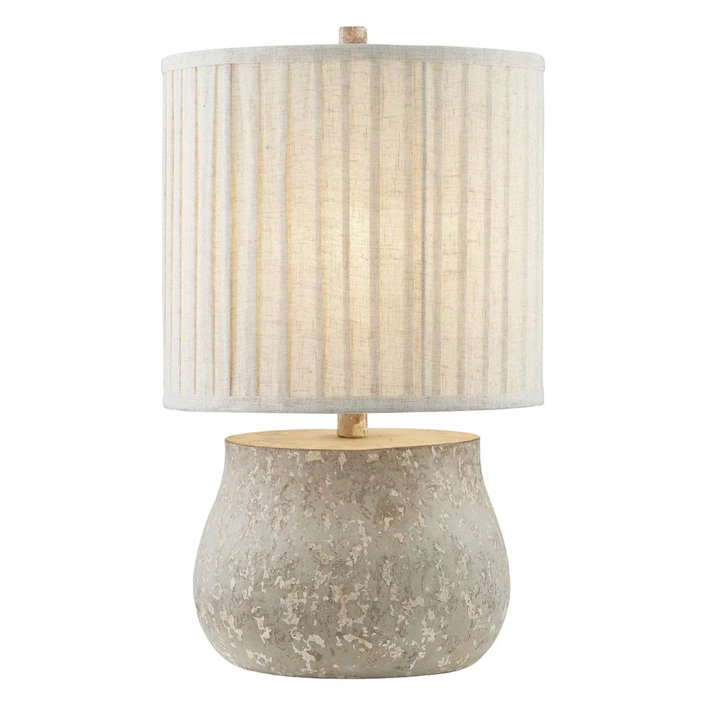 Rustic table lamp featuring a distressed stone base and a beige pleated drum lampshade for textured home decor.