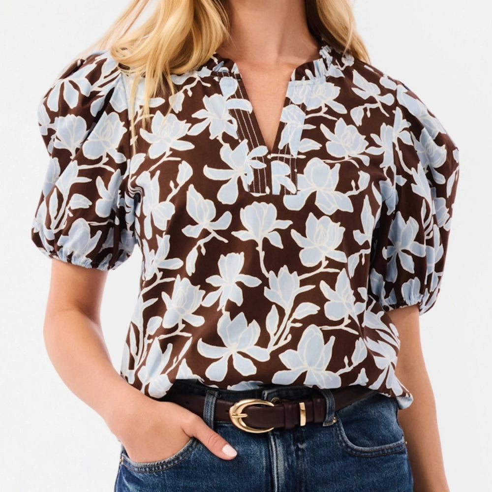 Front view of brown floral blouse with light blue pattern, puffed short sleeves, and split neckline.