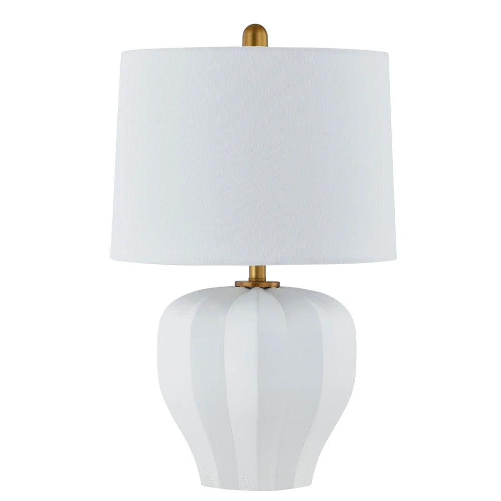 White ceramic table lamp with faceted sculptural base, white drum shade and brass finished hardware accents.