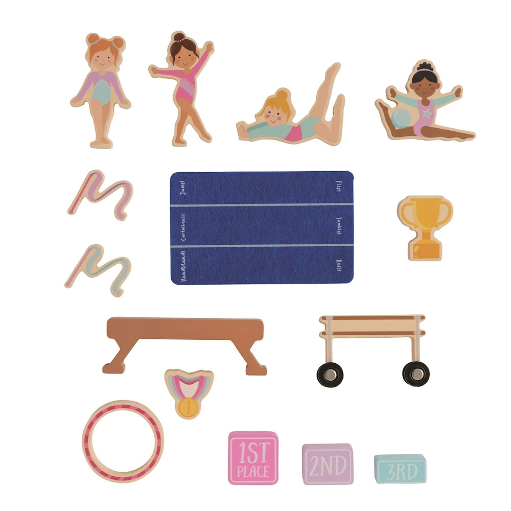 Wooden gymnastics toy set with diverse girl figures, balance beam, mat, trophy, and podium blocks on a white background.