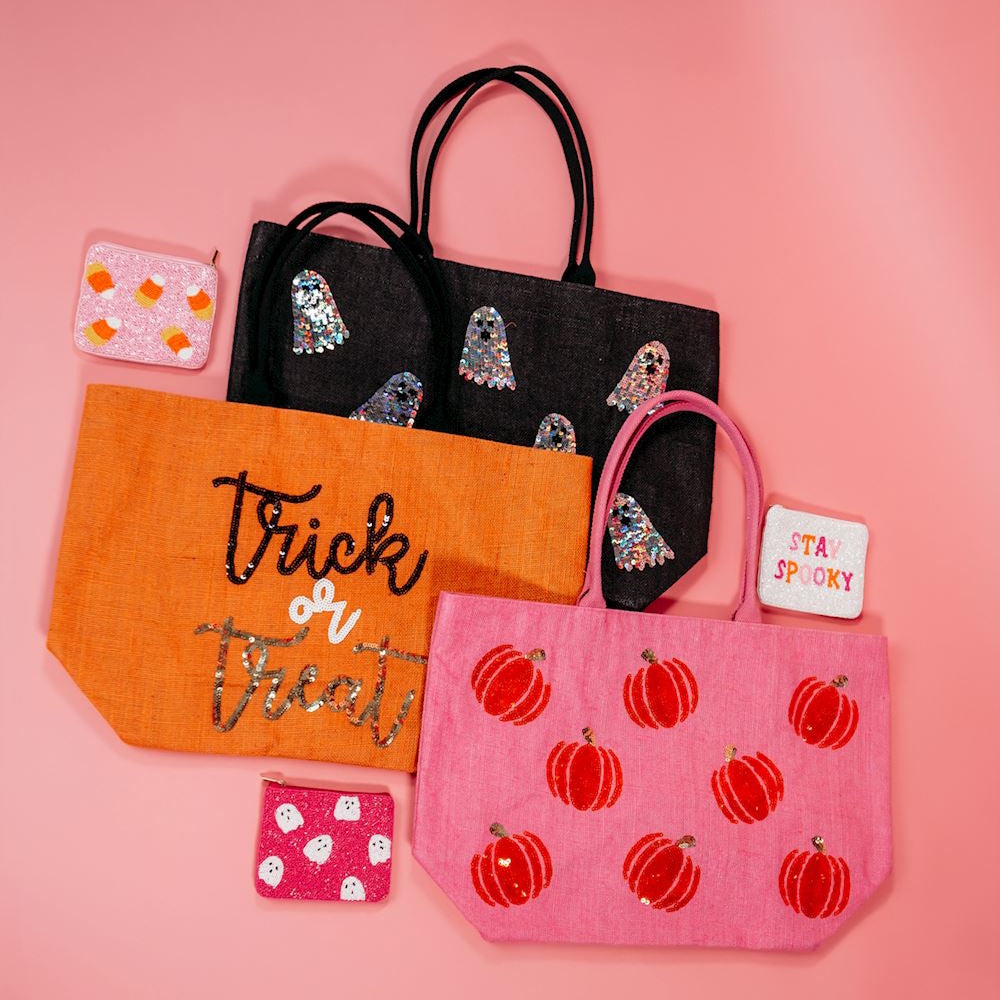 Halloween-themed tote bags and matching beaded pouches on a pink background.