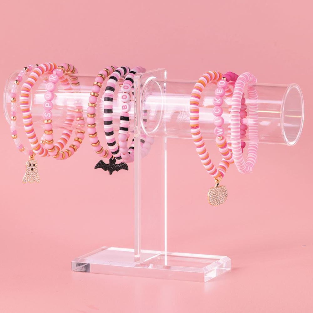 Pink Halloween beaded bracelet set with charms on a clear display stand.