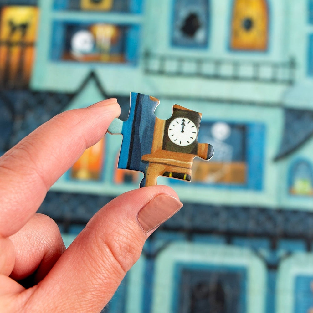 A hand holding a jigsaw puzzle piece with a clock, set against a blue haunted house puzzle background.