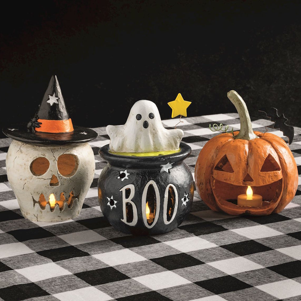 Three Halloween paper mache lanterns: a witch skull, a ghost in a BOO cauldron, and a glowing jack-o'-lantern.