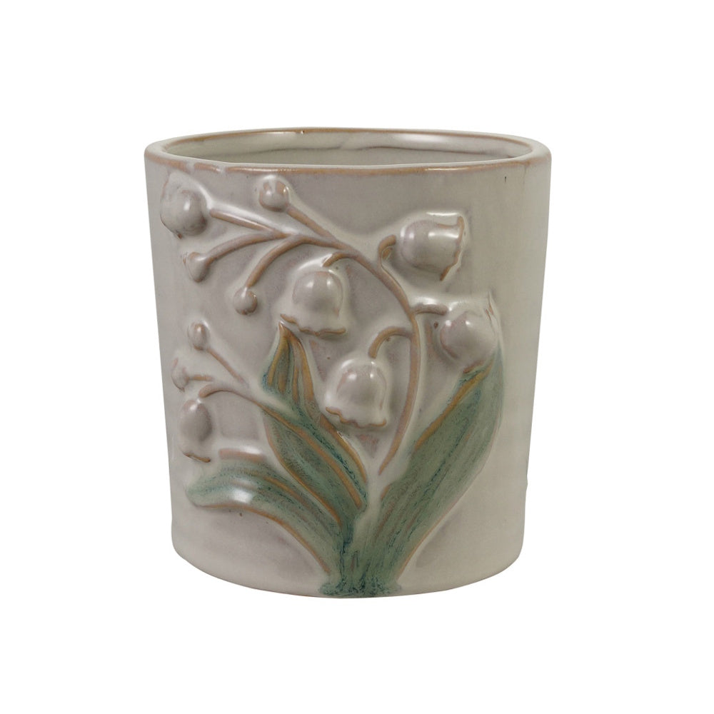 Embossed stoneware planter with lily of the valley flowers and green leaves on a light gray background.