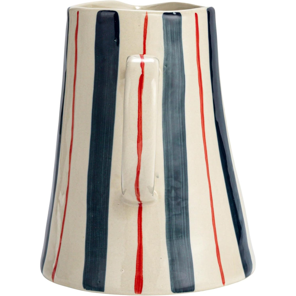 A hand-painted ceramic pitcher with vertical red, navy blue, and light grey stripes, focusing on the handle.