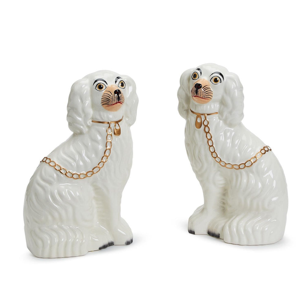 Pair of white hand-painted ceramic Staffordshire dog figurines with gold collar and chain details, facing outward.