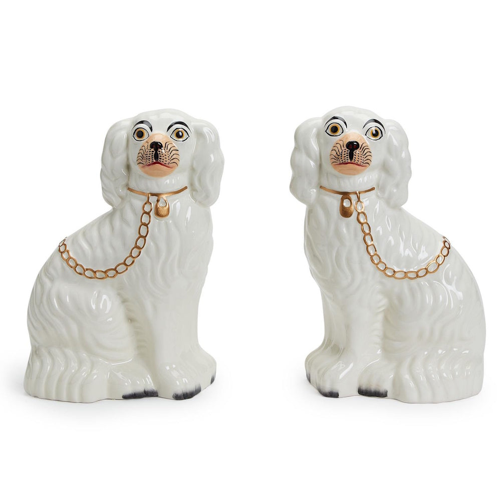 Pair of white hand-painted ceramic Staffordshire dog figurines with gold collar and chain details, facing each other.