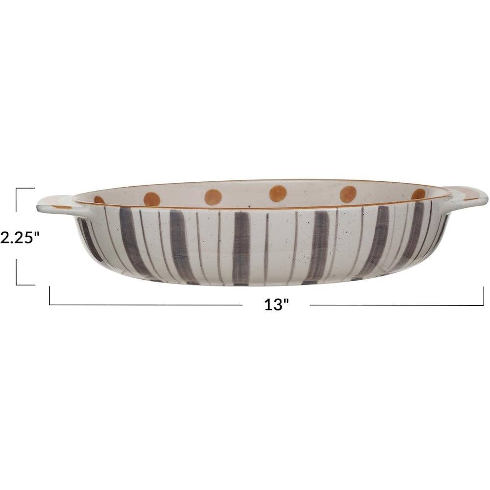 Oval baking dish with grey vertical stripes on exterior, brown dots inside. Measures 13 inches wide, 2.25 tall.