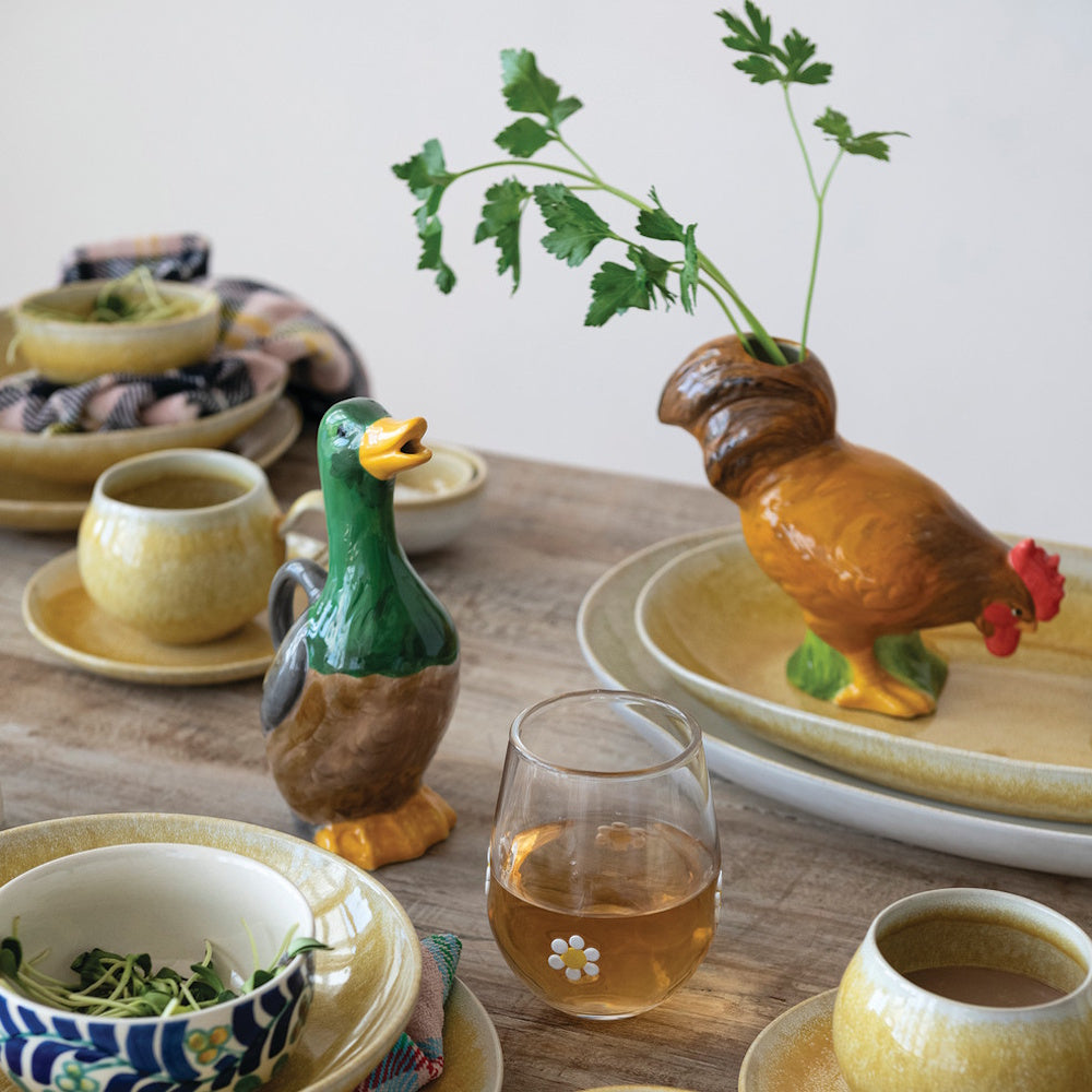 Hand-painted ceramic duck pitcher and rooster vase styled on a rustic wooden dining table.