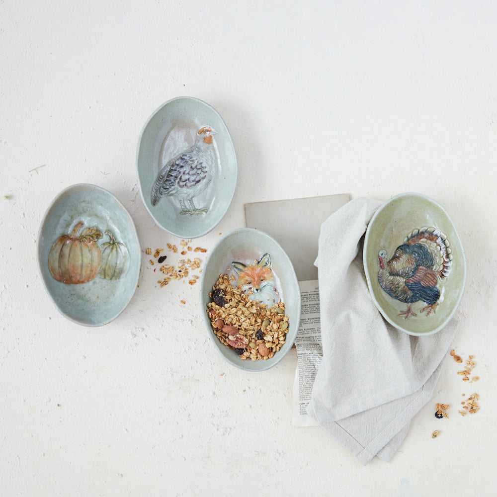 Hand-painted oval stoneware dishes featuring woodland animals, pumpkins, and granola.