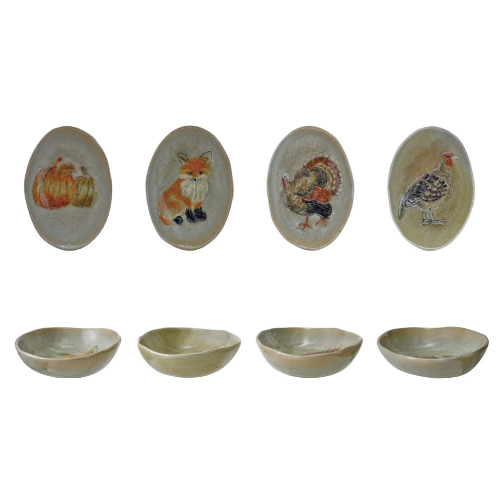 Four oval stoneware plates painted with autumn designs: pumpkins, fox, turkey, and pheasant.