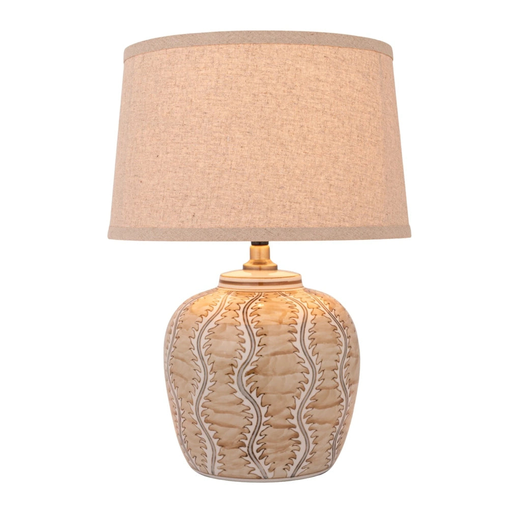Front view of the illuminated hand-painted ceramic table lamp featuring a brown leaf pattern base and glowing linen shade.