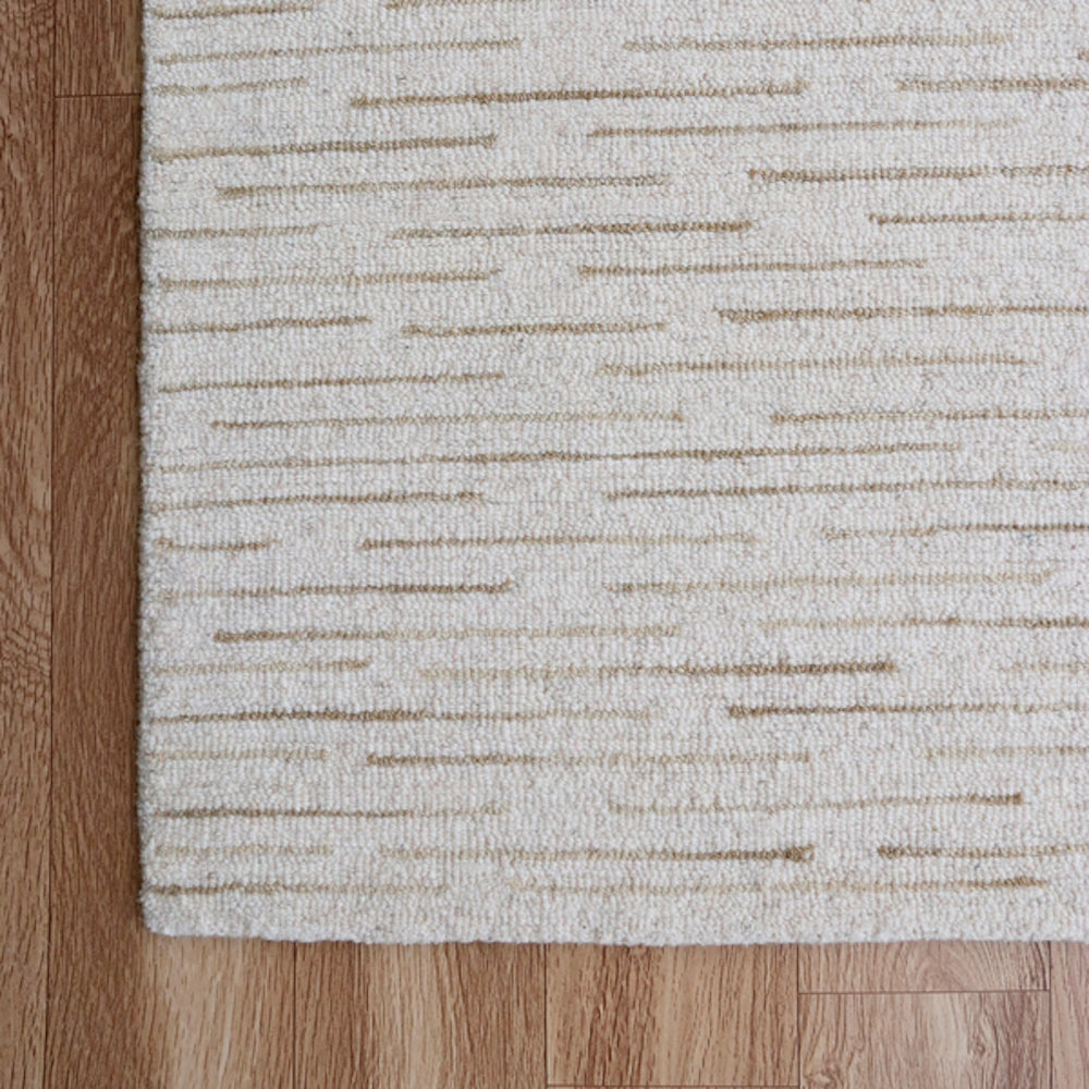 Hand-tufted rectangle Babylon rug in cream and beige with a textured linear pattern on a wood floor.