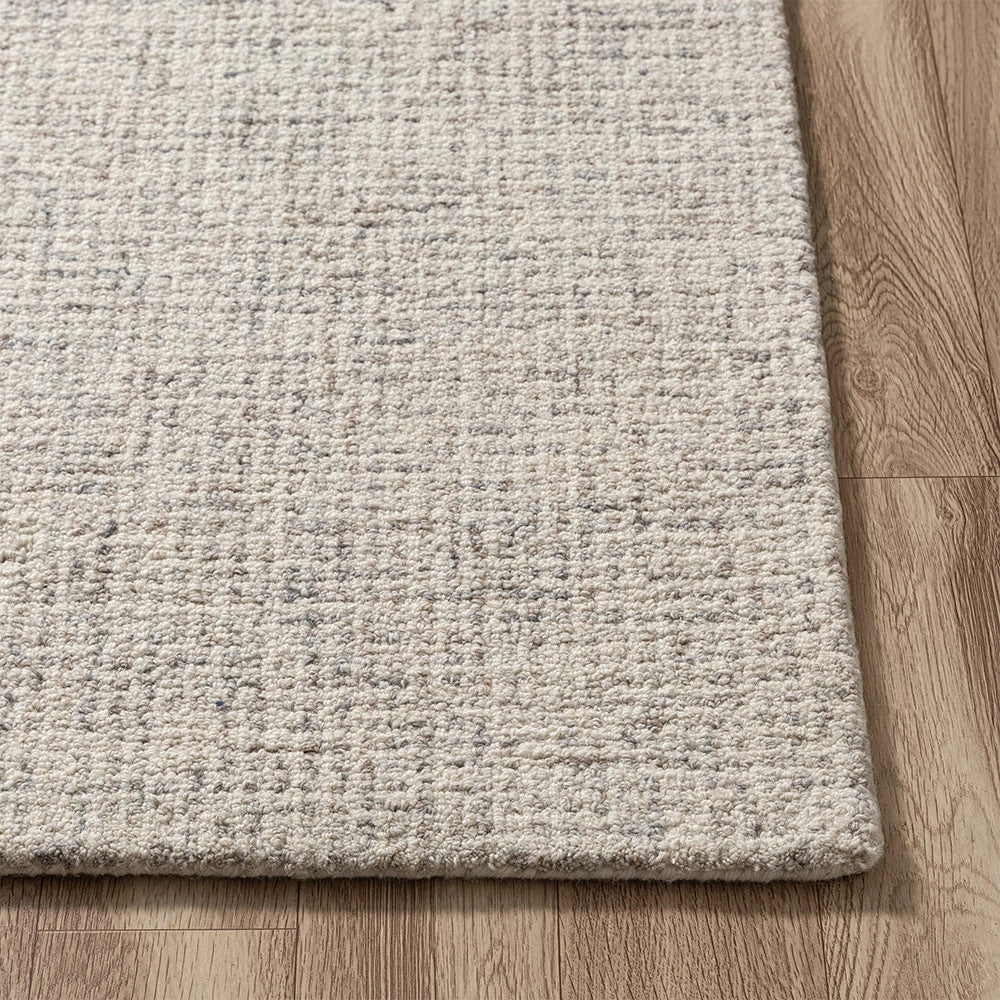 Neutral cream and grey textured wool area rug on a light wood floor.