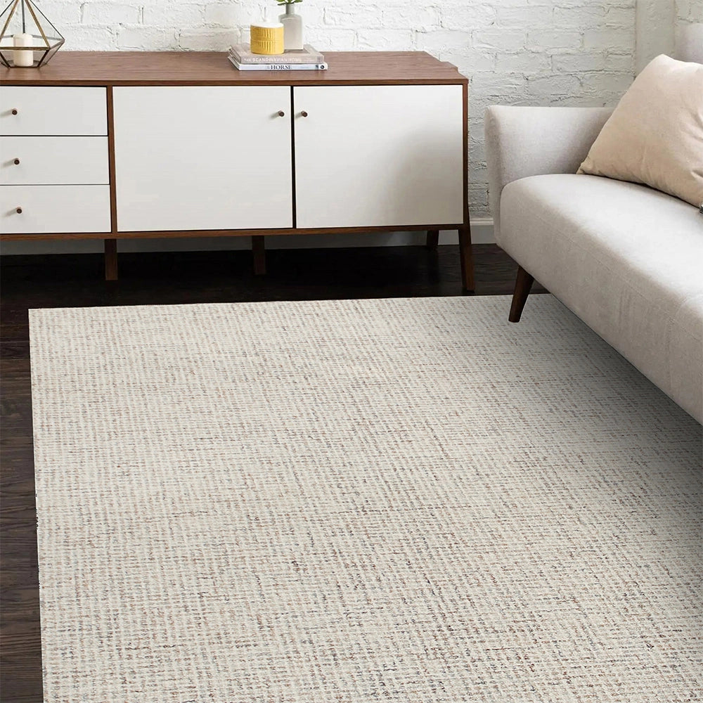 Modern cream textured area rug in a minimalist living room with a mid-century sideboard and gray sofa.