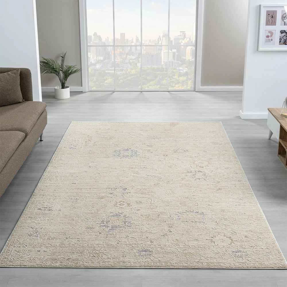 Beige hand-tufted Monaco area rug with a distressed vintage pattern in a modern living room setting.