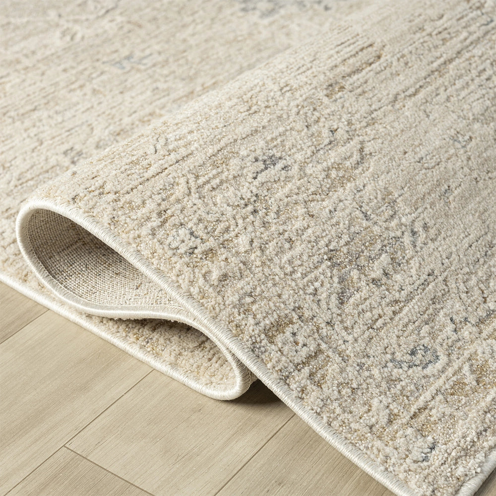 Close-up of a beige Monaco rectangle rug with a hand-tufted texture and subtle grey vintage pattern on a light wood floor.