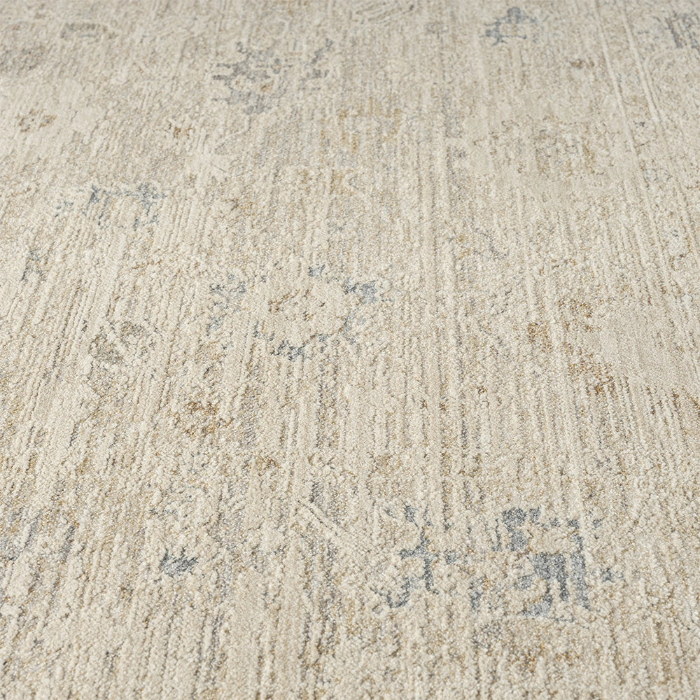 Beige hand-tufted Monaco area rug featuring a distressed traditional pattern with subtle blue and gold accents.