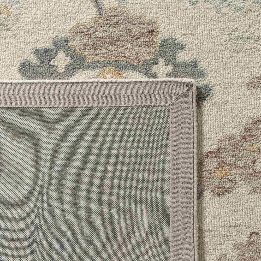 Cream hand tufted rectangle pallor rug showing a detailed view of its durable grey canvas backing.