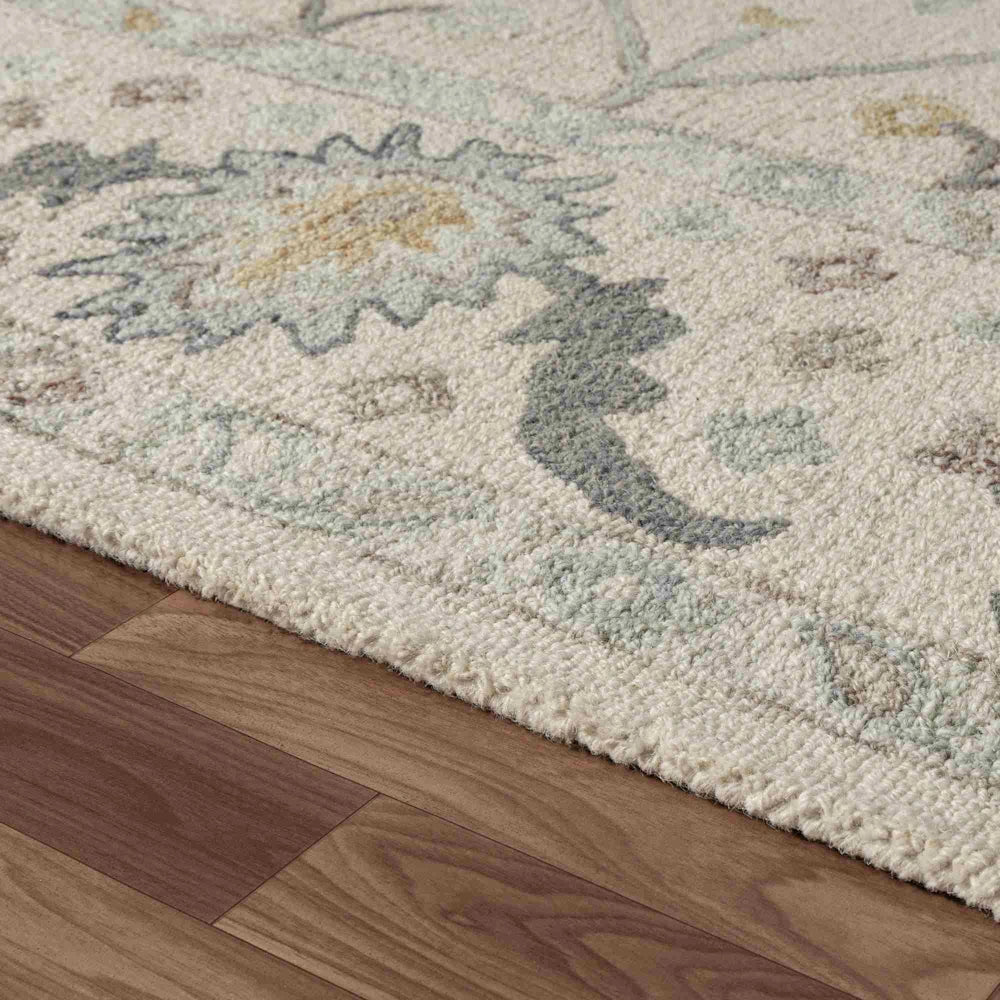 Cream hand tufted rectangle Pallor area rug with floral multi color pattern on wood floor.