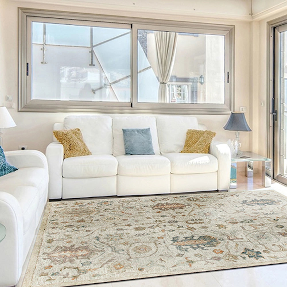 Ivory hand tufted rectangle vintage rug in a bright modern living room with a white sofa.