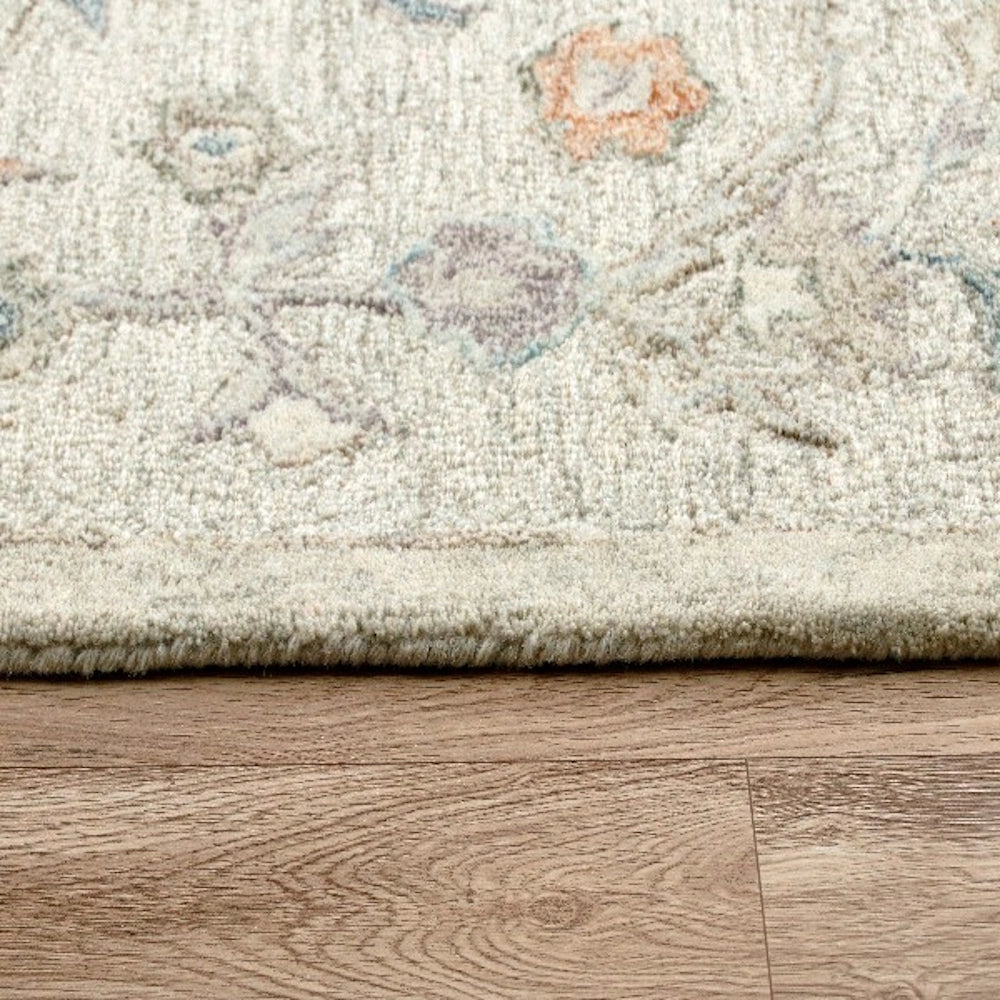 Hand-tufted rectangle vintage ivory rug with floral pattern on a wood floor.