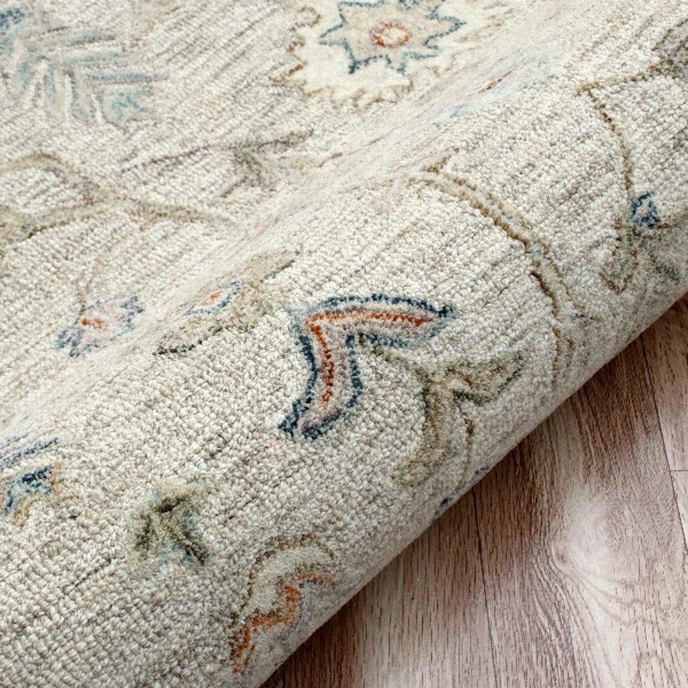 Close up texture details of a hand tufted rectangle vintage ivory area rug.
