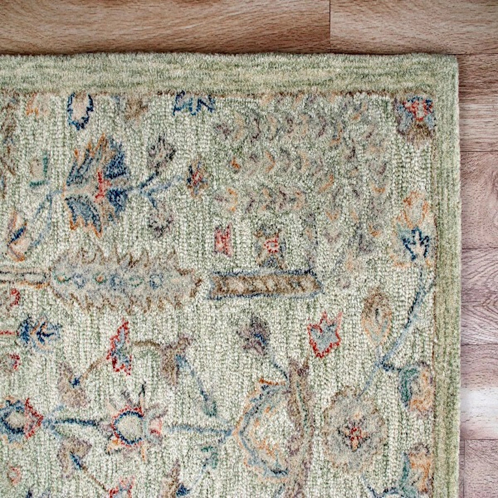 Sage hand tufted rectangle vintage rug showing a close up of the detailed floral pattern.