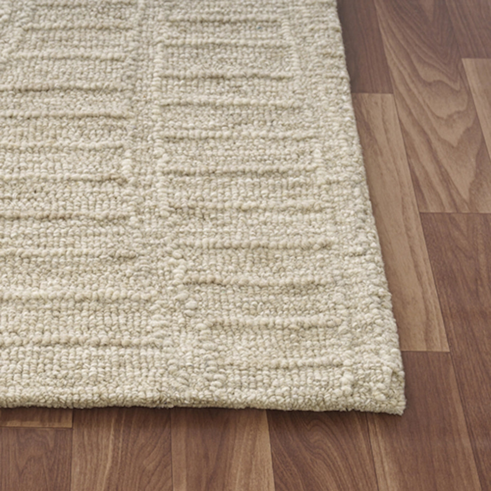 Close-up of a hand-tufted haze beige rectangle area rug with a textured loop pile pattern.
