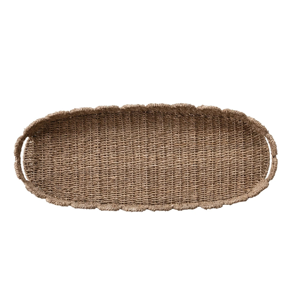 Top-down view of an empty oval hand-woven scalloped tray with handles on a plain white background.