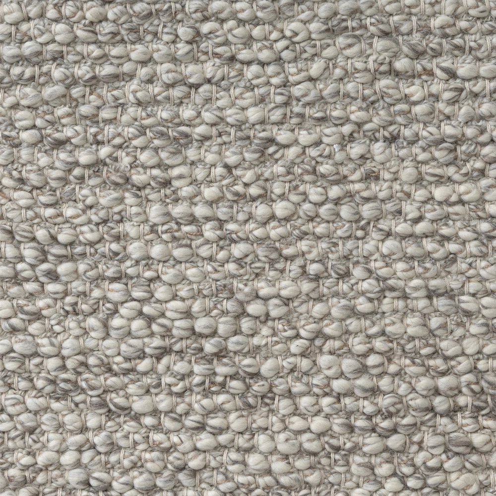 Chunky neutral hand-woven loop pile rug texture close up.
