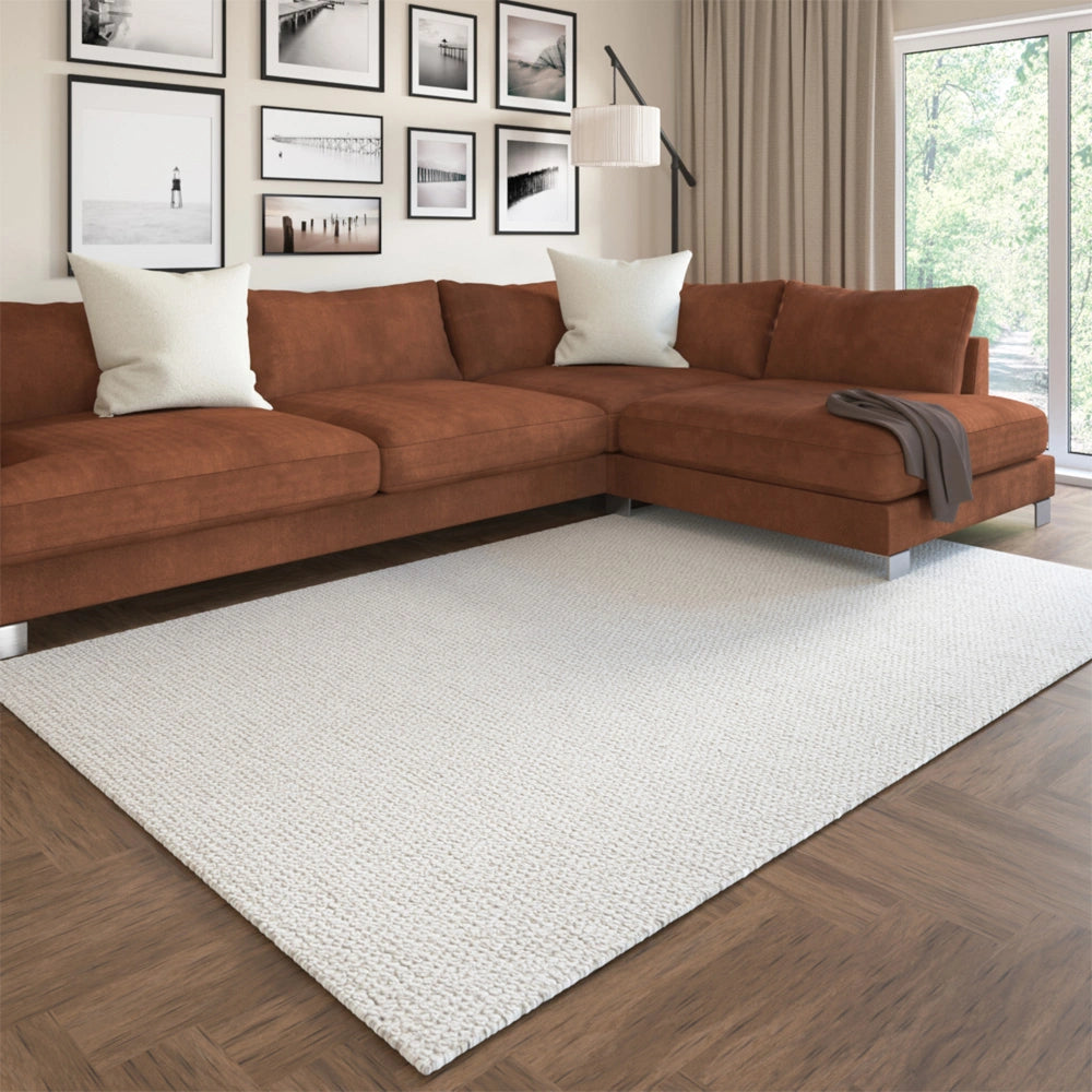 Hand-woven rectangle ivory dome rug in a living room with a brown sectional sofa.
