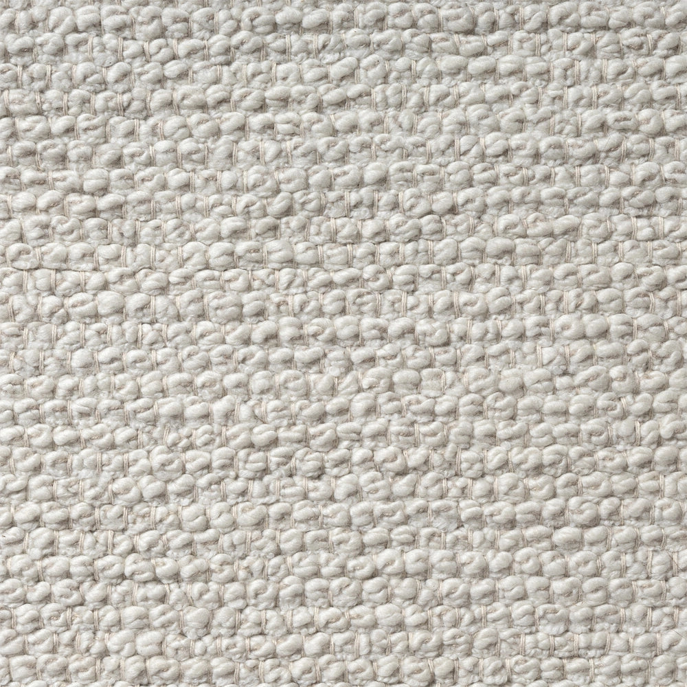 Textured close up of a cream white woven wool rug with a bumpy looped pile fabric pattern.