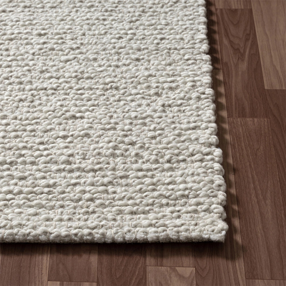 Close-up of a hand-woven rectangle ivory dome rug showing its thick textured loop pile on a hardwood floor.