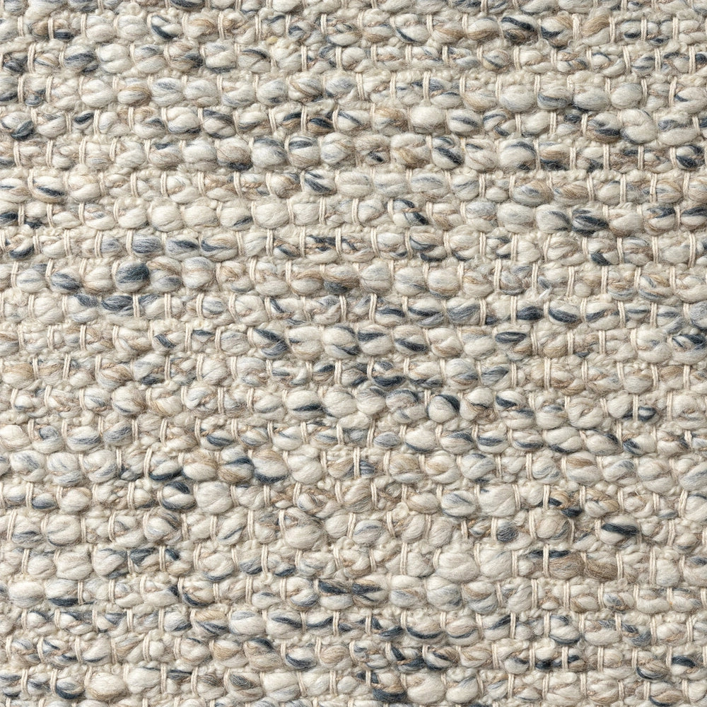 Texture of hand woven ivory rectangle dome rug with chunky wool loops in beige and grey.